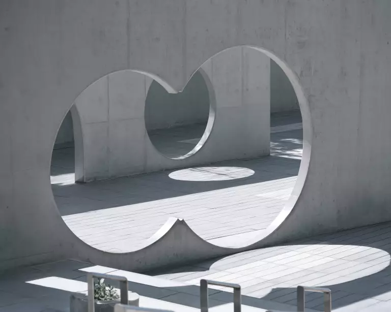 Betonarchitektur mit zwei großen kreisförmigen Öffnungen im Sonnenlicht