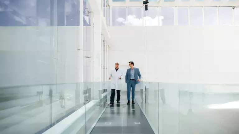Zwei Männer unterhalten sich beim Gehen durch ein Krankenhaus